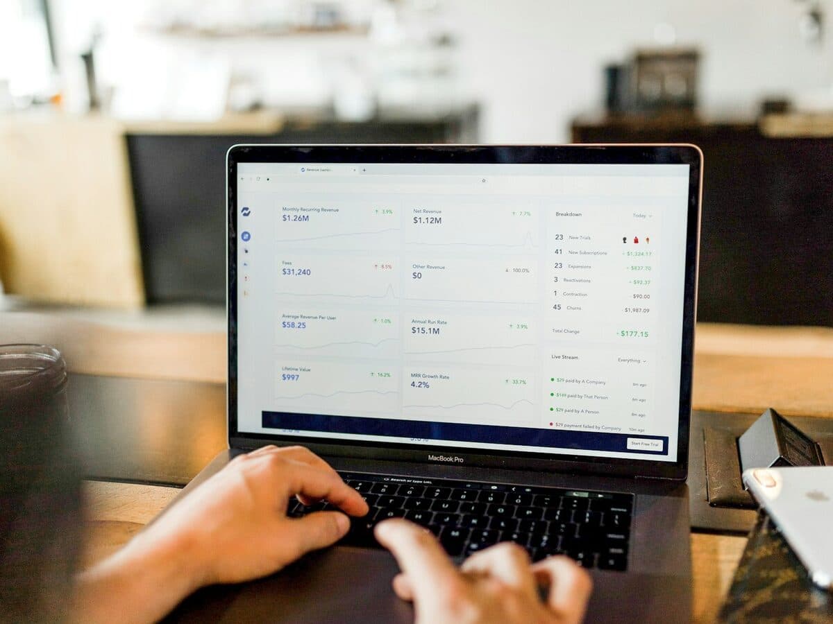 Person working on a laptop reviewing revenue and cost figures